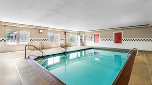 A swimming pool with a tiled deck, a changing room, and a window with a view. - Country Inn & Suites by Radisson, Hot Springs, AR (Hot Springs)