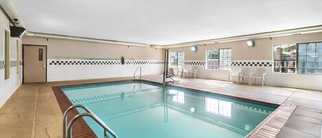 En swimmingpool med ett rutmönstrat kantparti, en poolstege och en kakelbeklädd poolterrass.