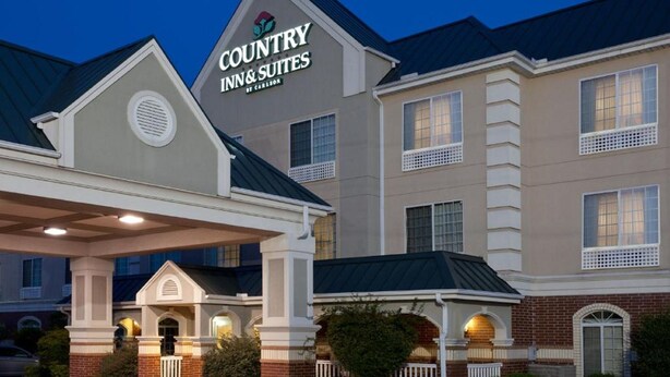 A Country Inn & Suites building with a prominent sign, a covered entrance, and a brick facade. - Country Inn & Suites by Radisson, Hot Springs, AR (Hot Springs)