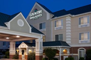 Edificio de Country Inn & Suites con un cartel llamativo, un acceso cubierto y fachada de ladrillo.