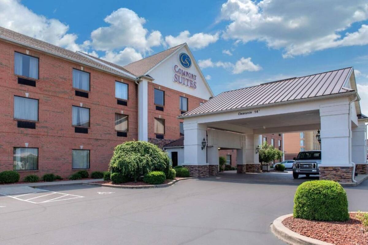 Ein Backsteinhaus mit einem Schild, auf dem 'Comfort Suites' steht, und einem überdachten Eingang.