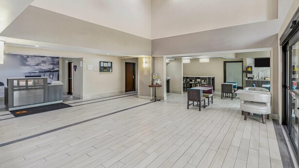 A spacious lobby with a reception desk, seating area, and a kitchen visible through an open door. - La Quinta Inn & Suites by Wyndham Batavia (Batavia)