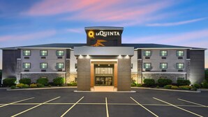 A La Quinta hotel with a modern design, featuring a prominent entrance and a parking lot. - La Quinta Inn & Suites by Wyndham Batavia (Batavia)