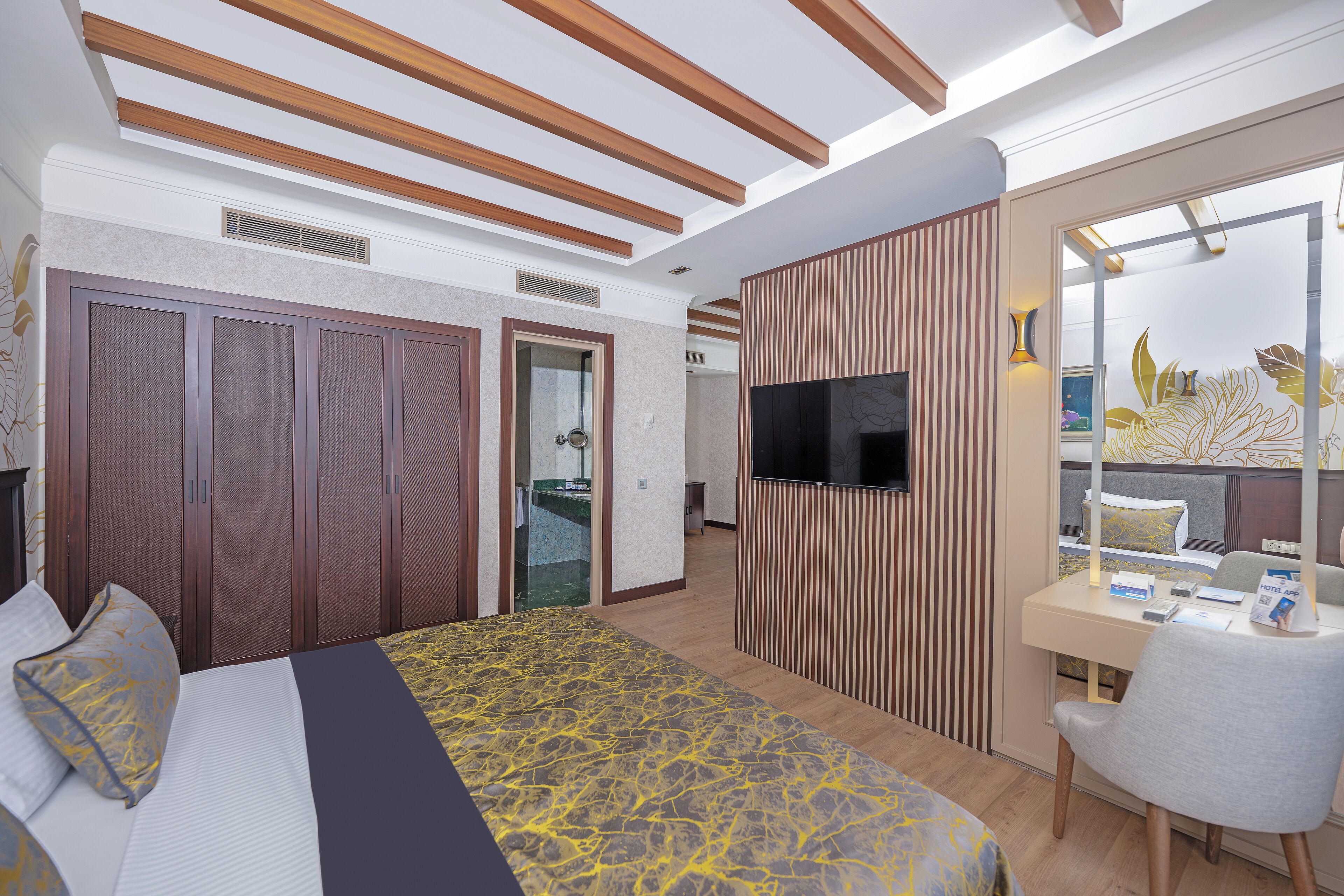 Une chambre d’hôtel moderne, dotée d’un grand lit, d’un bureau et d’une télévision.