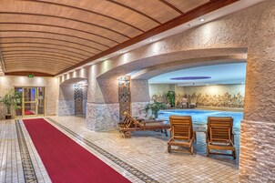 Ein Poolbereich mit Holzliegen und einem roten Teppich.