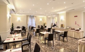 A hotel dining area with marble flooring, multiple tables, chairs, and a buffet counter. - Il Principe Hotel (Catania)
