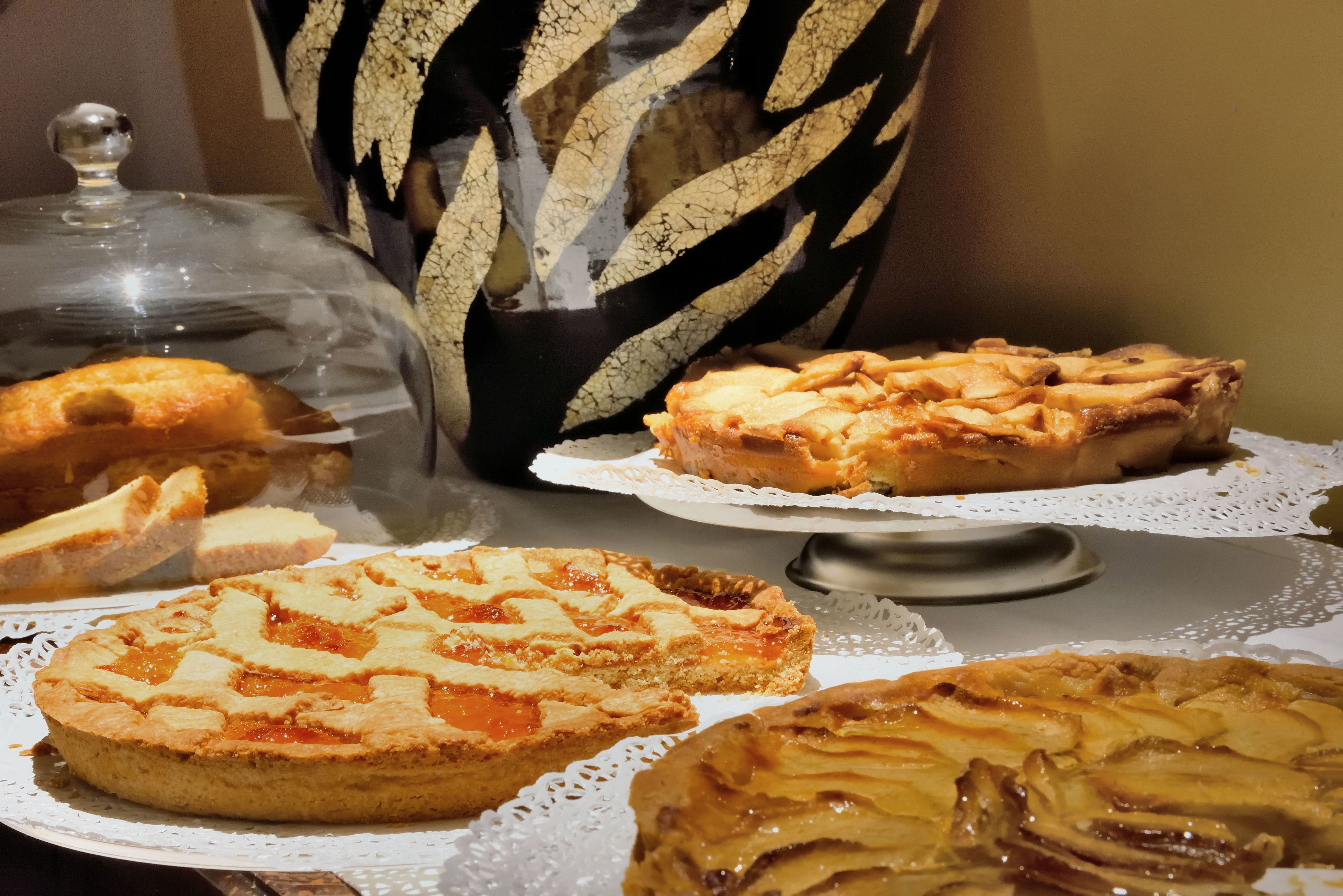 A variety of pies on a table with a lace doily.