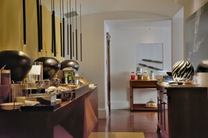 Un hall d’hôtel moderne avec un comptoir d’accueil, un miroir et un espace dédié au café.