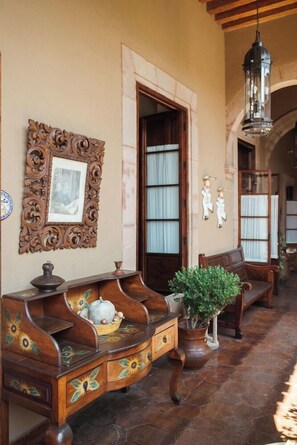 Un interno tradizionale con mobili in legno, un pannello decorativo e un lampadario appeso.