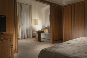 Una habitación de hotel con cama, televisión, escritorio y sofá.