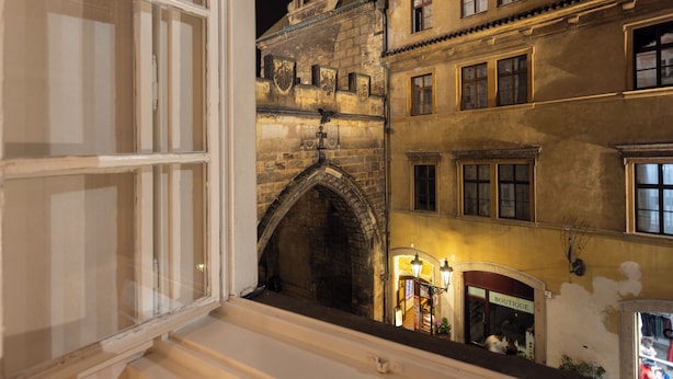Vista dalla finestra su un edificio con un arco visibile e l'ingresso di una boutique.