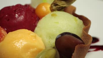 Un dessert con diversi frutti e un pezzo di cioccolato su un piatto bianco.