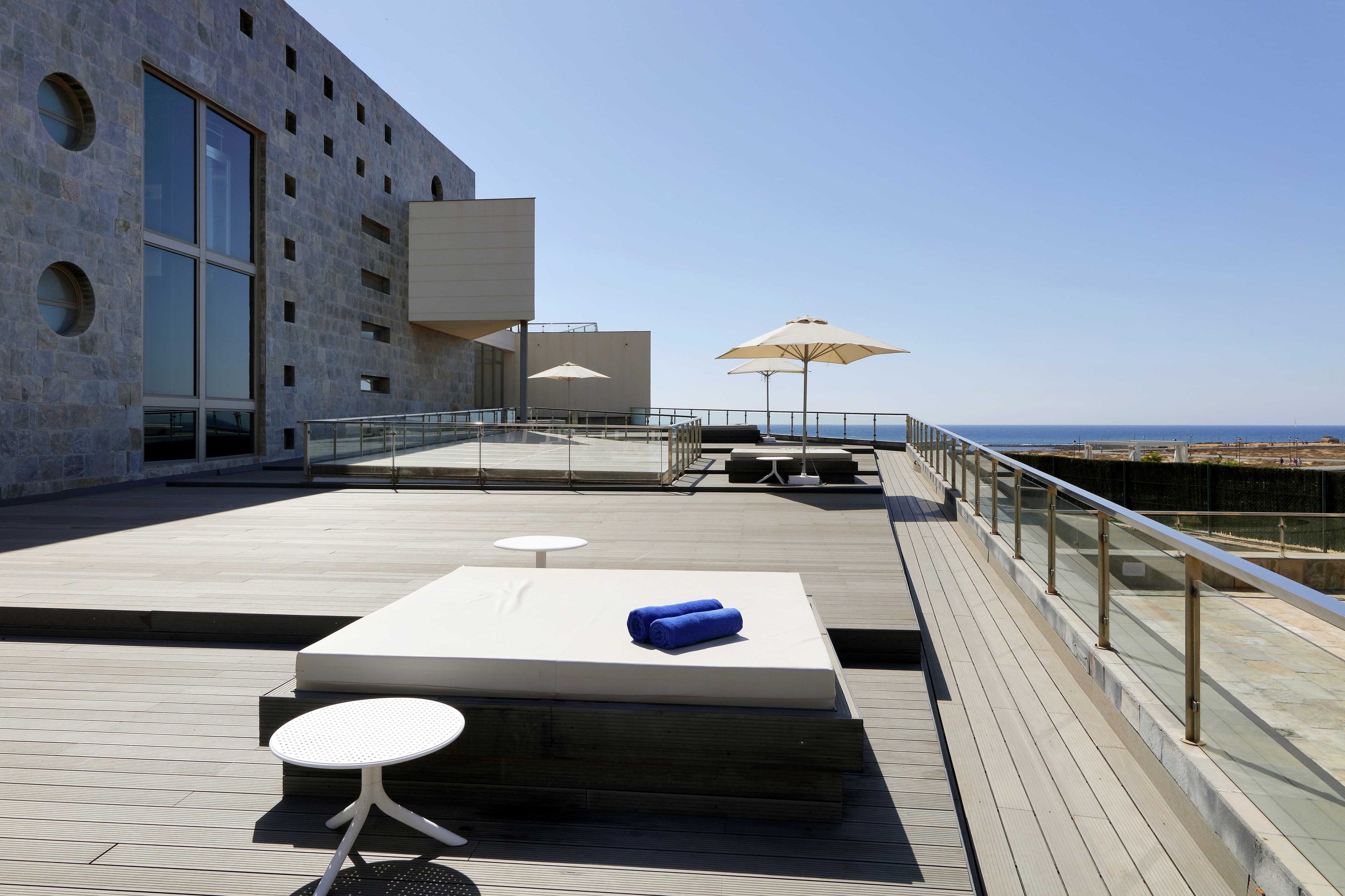 Eine Dachterrasse mit Billardtisch, Liegestühlen und Sonnenschirmen.