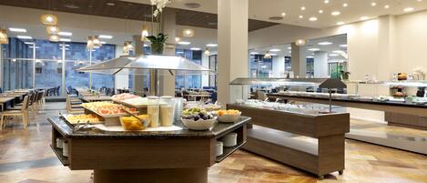 Un buffet proposant une variété de plats et agrémenté d’une plante décorative placée au centre.