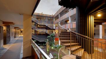 Un intérieur à plusieurs niveaux, doté d’un atrium central, d’un escalier et offrant une vue sur le ciel.
