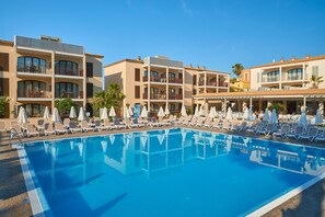 A swimming pool with sun loungers and umbrellas, surrounded by multi-story buildings with balconies. - Protur Floriana Resort Aparthotel - All inclusive (Son Servera)