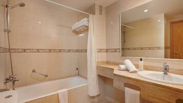 Un baño con bañera, lavamanos y ducha.