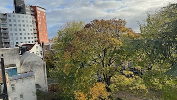 A residential area with a mix of modern and older buildings, including a prominent red building and a white building with a unique design.