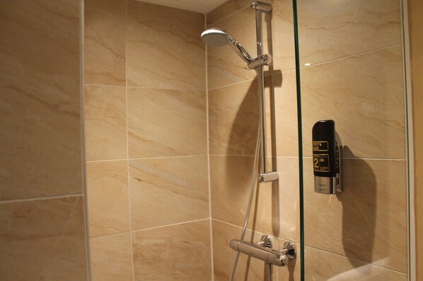A shower with a handheld showerhead and a wall-mounted control panel. - Aston City Hotel (Amsterdam)