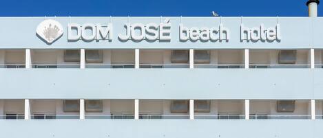 Un edificio de varios pisos con un cartel que dice 'DOM JOSÉ beach hotel'.