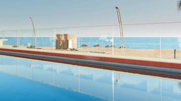 Una piscina con vistas despejadas a la playa y al océano.
