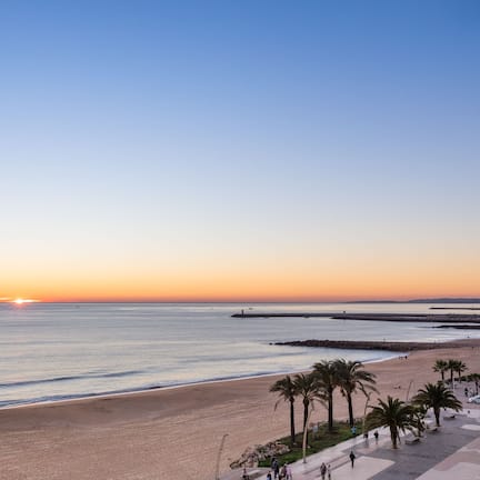 On the beach, white sand, beach cabanas, sun loungers