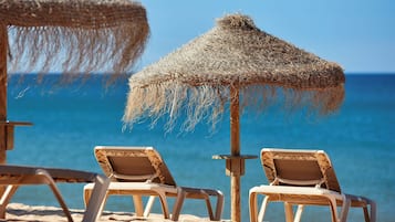 On the beach, white sand, beach cabanas, sun-loungers