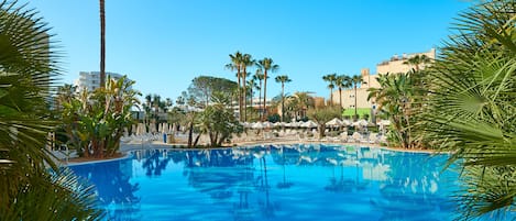 Una piscina cubierta, una piscina al aire libre, tumbonas