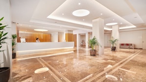 A spacious lobby with a reception desk, potted plants, and a polished marble floor. - Hipotels Said (Sant Llorenc des Cardassar)