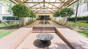 A covered walkway with a central planter, flanked by steps leading to a building entrance. - Hipotels Said (Sant Llorenc des Cardassar)