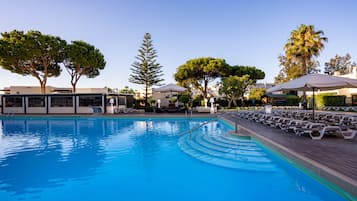 Una piscina al aire libre de temporada, sombrillas