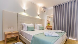 A hotel room with a large bed, bedside tables, a nightstand, a mirror, and a window with curtains. - Albufeira Sol Hotel & Spa (Albufeira)