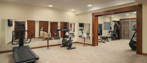 A gym with treadmills, elliptical machines, and weight equipment.