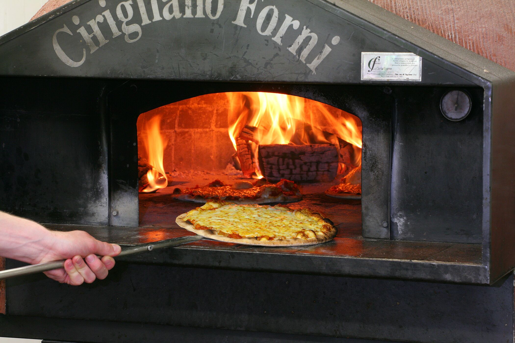 A pizza oven with a sign reading "Cirigliano Forni".