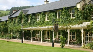 A traditional building with a covered patio area, multiple windows, and a well-maintained lawn. - Brooklodge & Macreddin Village (Macreddin Village)