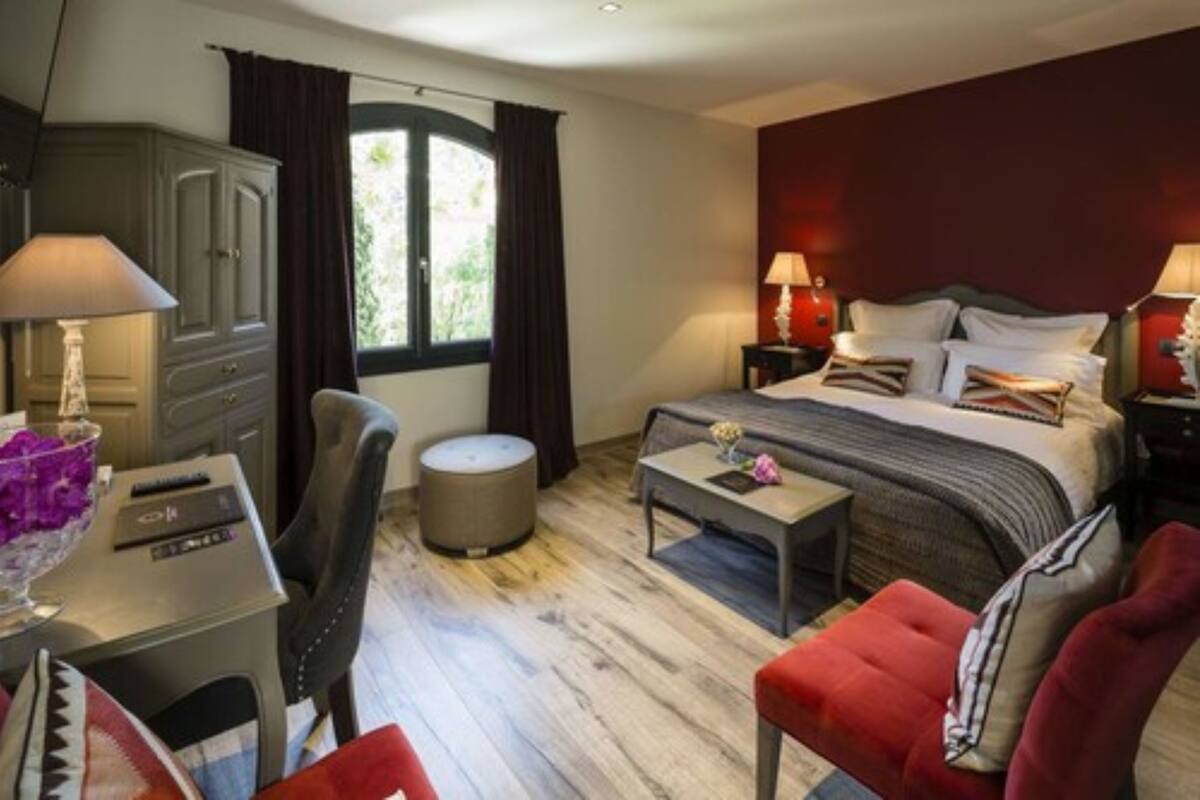 Un dormitorio con cama, mesitas de noche, escritorio, silla y armario.