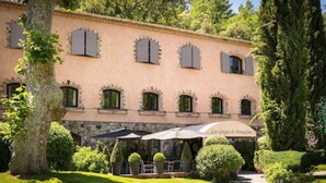 A building with a garden patio area, outdoor seating, and a sign that reads "Les Gorges de Penon-Haut." - Hostellerie Les Gorges de Pennafort (Callas)
