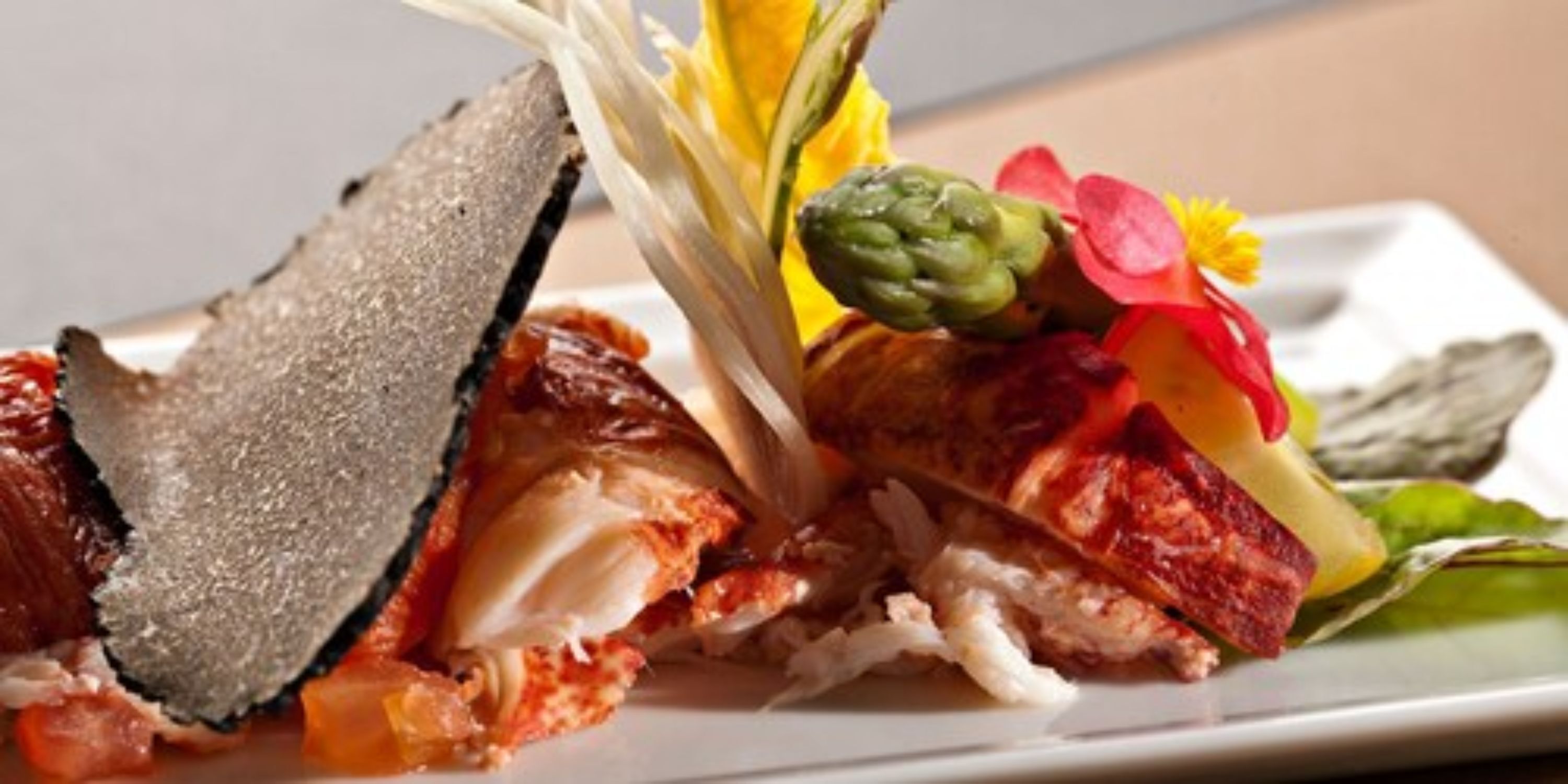 A seafood dish with a variety of ingredients including a piece of fish, asparagus, and possibly some vegetables.