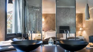 A modern bathroom with two black sinks, a large mirror, and a shower area visible through a glass partition. - Hostellerie Les Gorges de Pennafort (Callas)