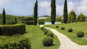 A well-maintained garden with a gravel path, neatly trimmed hedges, and tall cypress trees. - La Chartreuse du Bignac (Saint-Nexans)