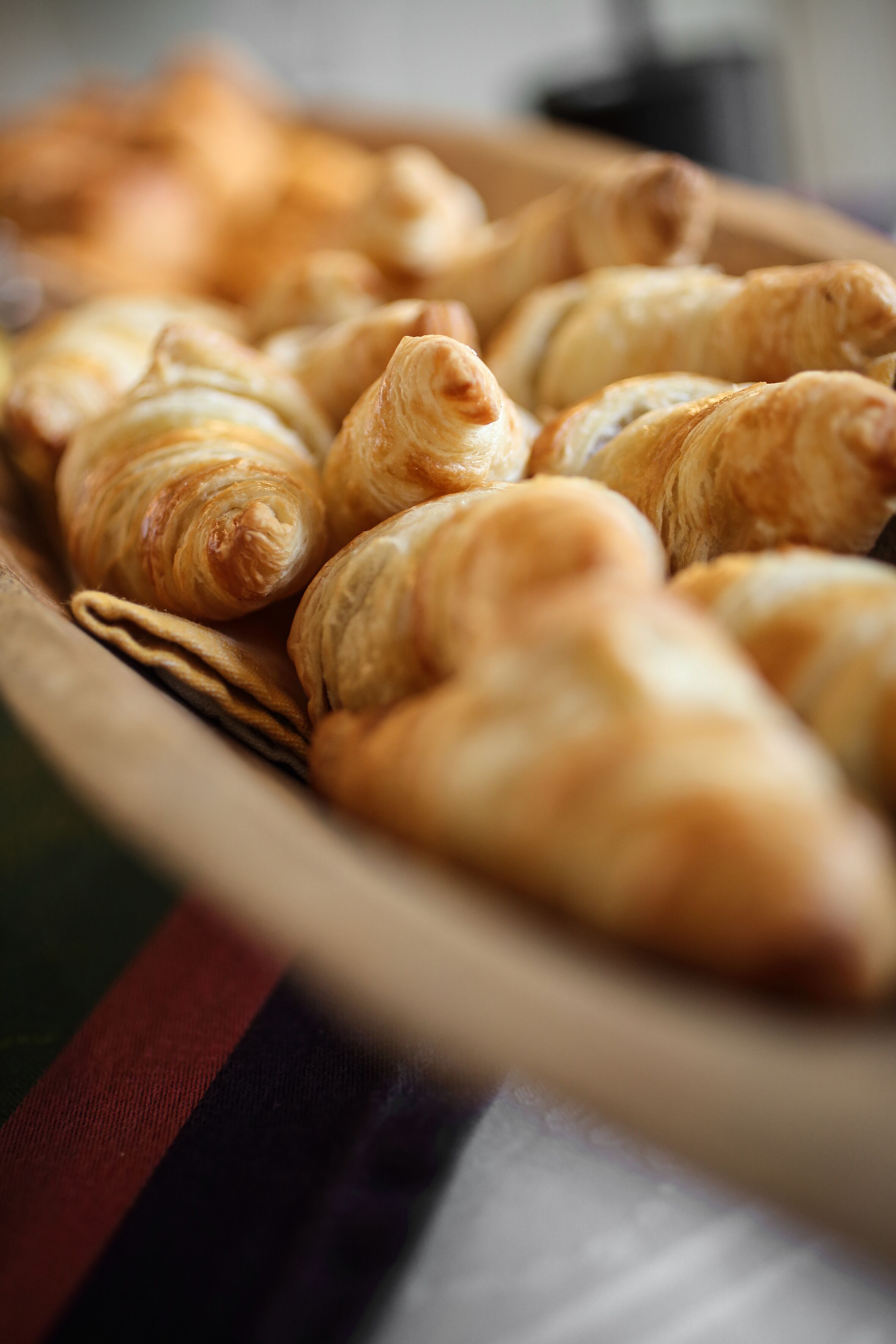 A wooden tray filled with croissants.