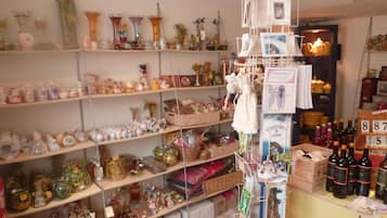 Een rommelige kamer met planken vol diverse spullen, zoals potten, flessen en decoratieve objecten.