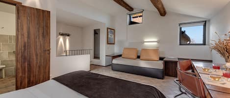 Quarto moderno com uma cama grande, uma escrivaninha e um espaço para refeições.