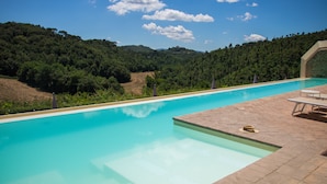 Una piscina con vistas despejadas al bosque y las colinas circundantes.
