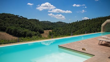 Una piscina cubierta, una piscina al aire libre de temporada, tumbonas