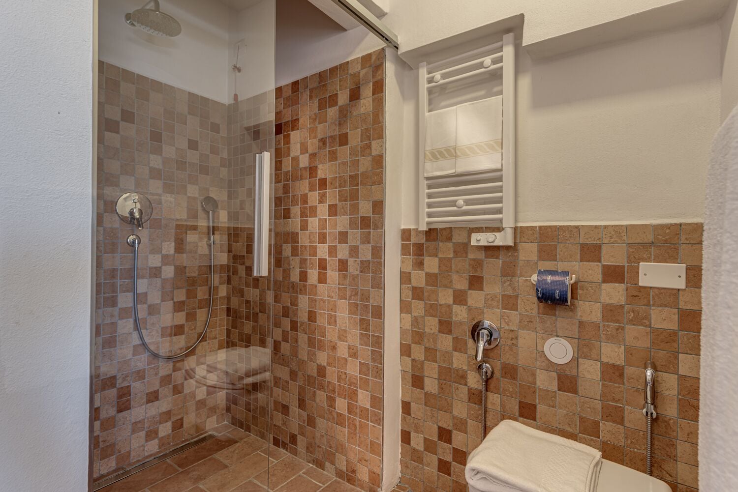 A bathroom with a shower, toilet, and sink.