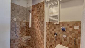 A bathroom with a shower, toilet, and sink.