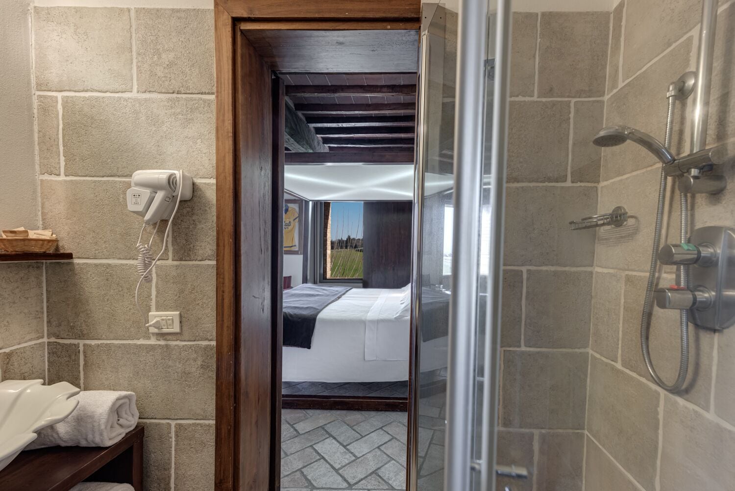 Une salle de bain moderne équipée d’une douche, d’un sèche-cheveux et d’un porte-serviettes.