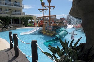 En swimmingpool med vandrutsjebaner og en træterrasse med gelændere.
