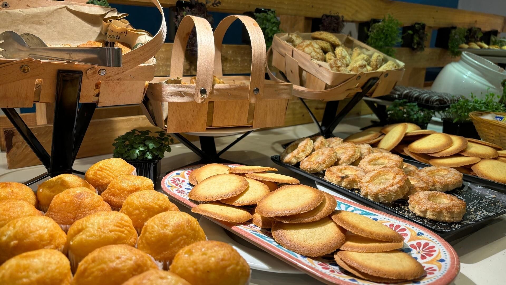 Un buffet proposant une variété de produits de boulangerie, notamment des pâtisseries et des biscuits.